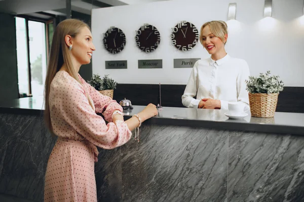 Check-in degli ospiti dell'hotel per donne bionde alla reception dell'hotel — Foto Stock