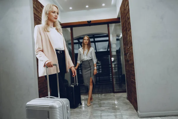 Δύο νεαρές γυναίκες με επίσημα ρούχα εισέρχονται στο λόμπι του ξενοδοχείου — Φωτογραφία Αρχείου