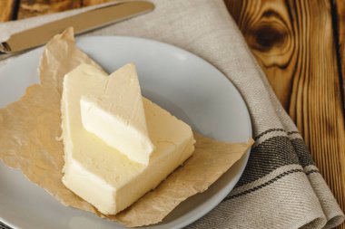 Tahta masadaki bir tabakta tereyağı dilimleri