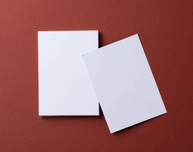 Burgundy kağıt arka planında boş beyaz kartvizitler