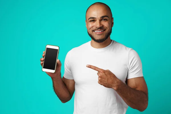 Gülümseyen Afrikalı Amerikalı adam akıllı telefon ekranını işaret ediyor. — Stok fotoğraf