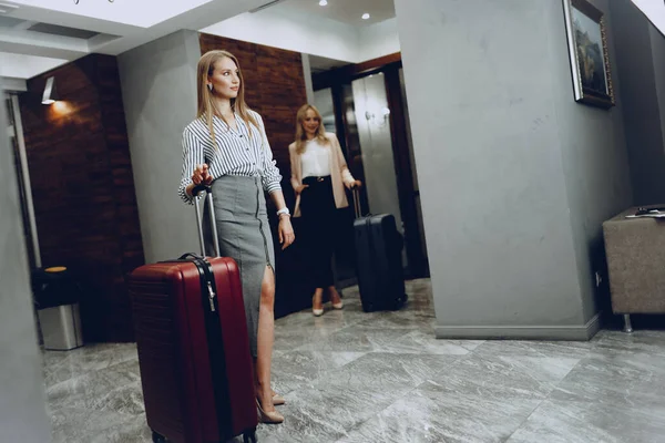 Zwei junge Frauen in formeller Kleidung betreten Hotellobby — Stockfoto