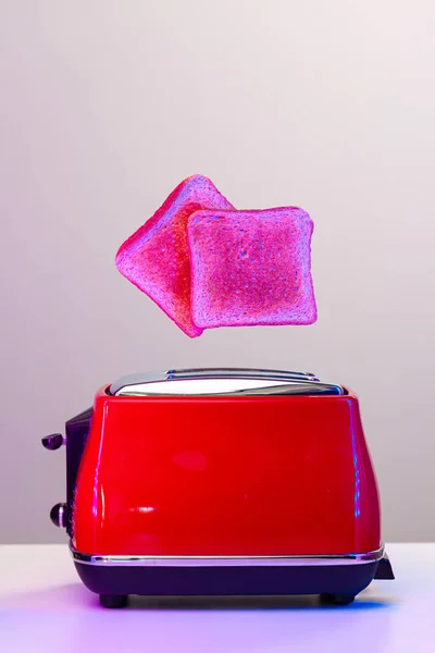 Duas fatias de torrada saltando da torradeira em luz de néon — Fotografia de Stock