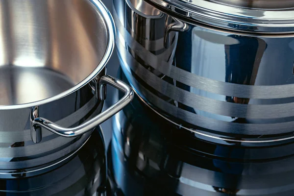 Set van aluminium pannen op zwart oppervlak close-up — Stockfoto