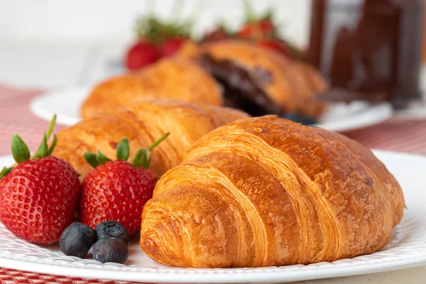 Croissant fresco decorato con bacche su tavola di legno bianca — Foto Stock