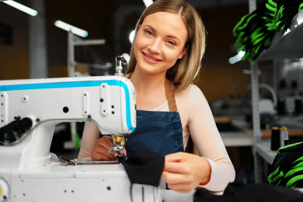 Seamstress mulher em seu local de trabalho roupas de costura na máquina de costura — Fotografia de Stock