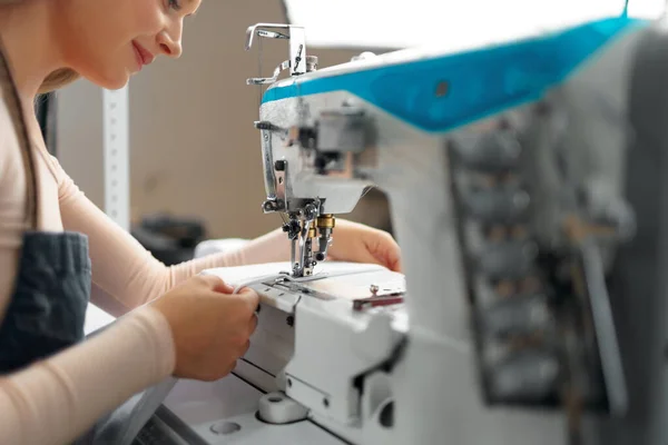 Seamstress mulher em seu local de trabalho roupas de costura na máquina de costura — Fotografia de Stock