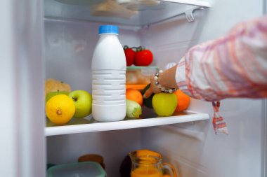 Buzdolabından yemek alan bir kadının eli.