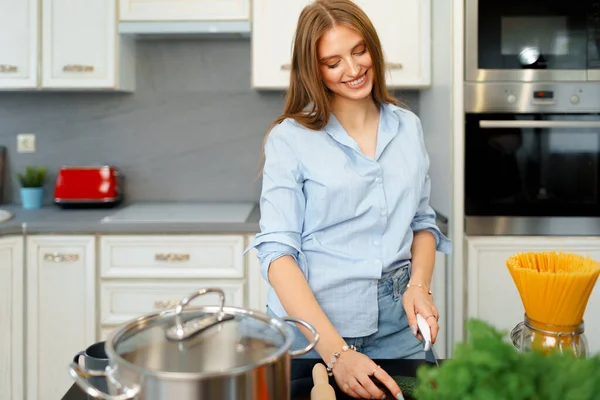 Mujer joven cortando verduras para ensalada en la cocina —  Fotos de Stock