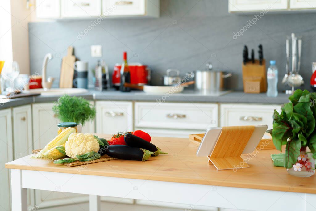 Kitchen table with frsh vegetables and digital tablet