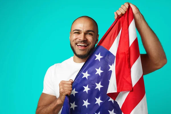 Retrato de un joven de piel oscura sosteniendo orgullosamente la bandera de EE.UU. —  Fotos de Stock