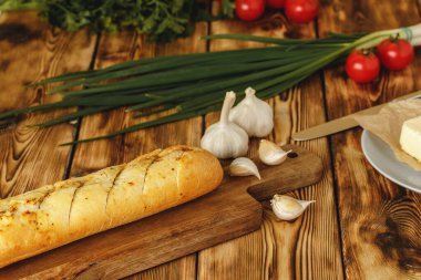 Sarımsak yağı ve bitkilerle dilimlenmiş taze baget.