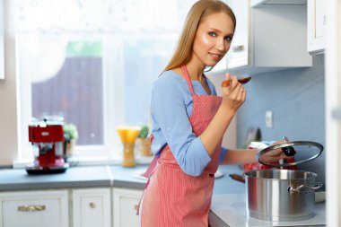 Çekici genç sarışın kadın yemek hazırlıyor.