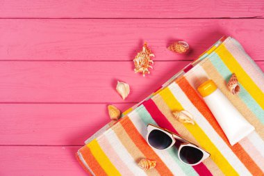 Ahşap zemin üzerinde deniz kabukları olan plaj aksesuarları.