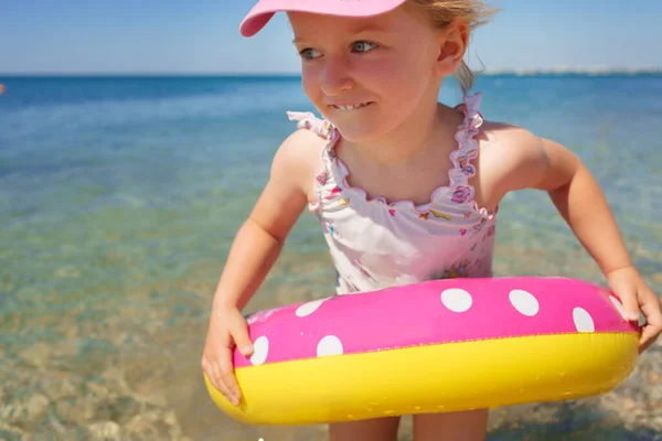 Petite fille en bikini nageant en mer avec cercle de natation — Photo
