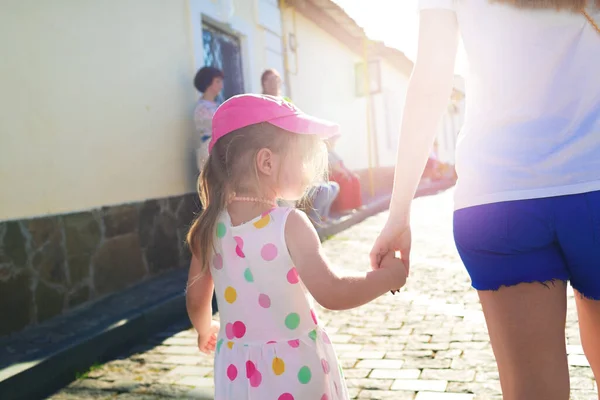 Mère et fille marchant par la main dans la ville — Photo