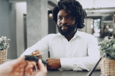 Oteldeki konaklama ücretini kredi kartıyla ödeyen Afrikalı işadamı.