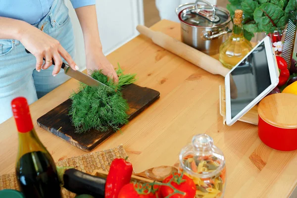 Jovem mulher branca loira cortando legumes para salada em sua cozinha — Fotografia de Stock