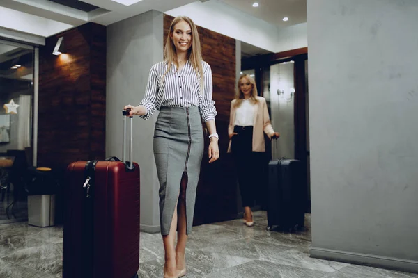 Zwei junge Frauen in formeller Kleidung betreten Hotellobby — Stockfoto