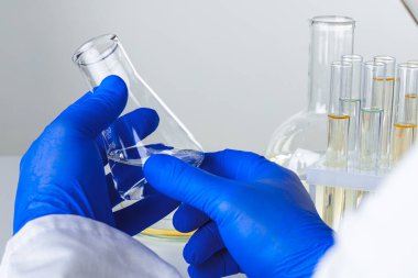 Laboratuvar örnekleriyle çalışan bir bilim adamının ellerine yakın çekim