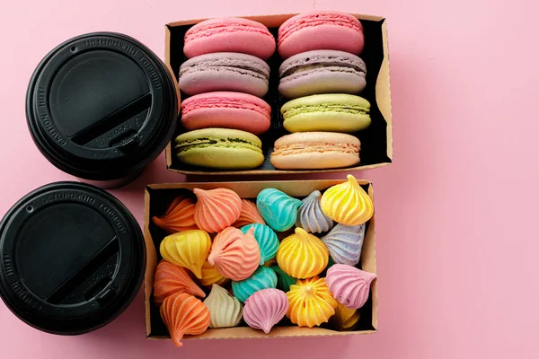 Taza de café de cartón negro con caja de galletas de merengue de colores en rosa —  Fotos de Stock