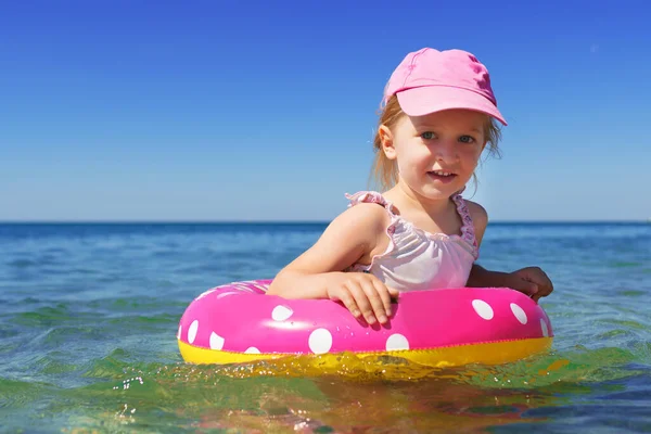 Petite fille en bikini nageant en mer avec cercle de natation — Photo