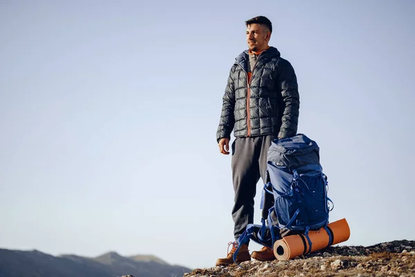Zaino in spalla maschile in attrezzature escursionistiche in piedi in cima alla montagna — Foto Stock
