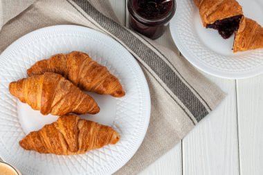 Ahşap masada taze kruvasan var. Yakın çekim.