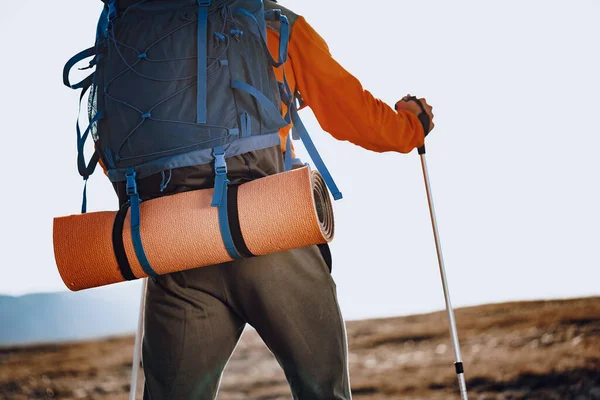 Man traveler with trekking sticks going up the mountain — Stock Photo, Image