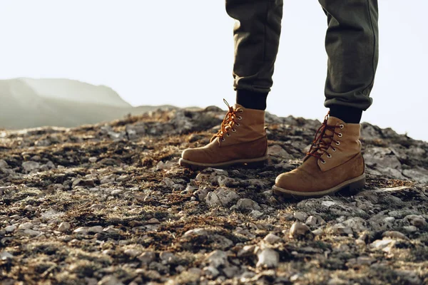 Benen van een backpacker in wandelschoenen op de top van de berg — Stockfoto
