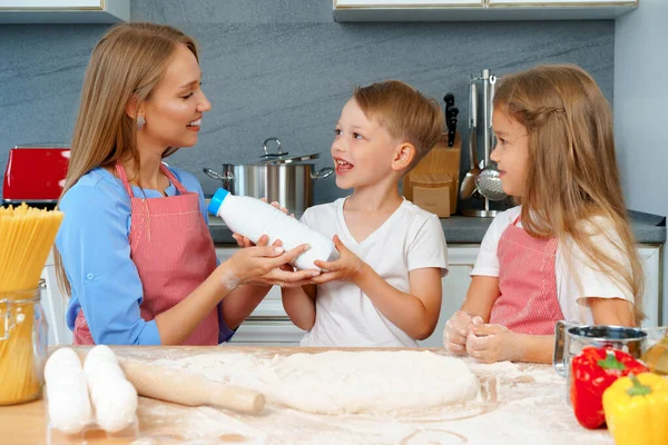 Jovem mãe e seus filhos bonitos cozinhar pizza juntos — Fotografia de Stock