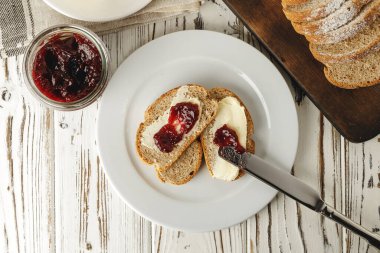 Masada tereyağı ve reçelli taze ekmek dilimi