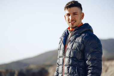 Dağlarda yürüyüş yapan beyaz bir gencin portresi.