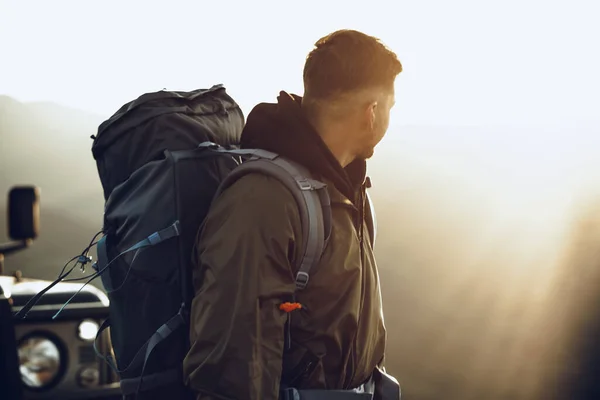 オフロード車の近くに立っているハイキング機器の若い旅行者の肖像画 — ストック写真