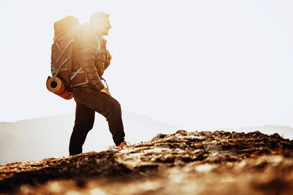 Férfi hátizsákos túrázó felszerelés áll a hegy tetején — Stock Fotó