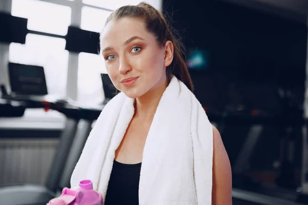 Junge sportliche Frau trinkt nach dem Training einen Drink im Fitnessstudio — Stockfoto