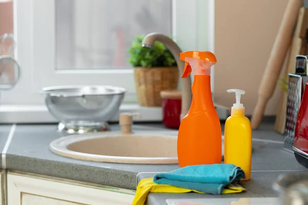 Household chemicals product bottles standing near the kitchen sink