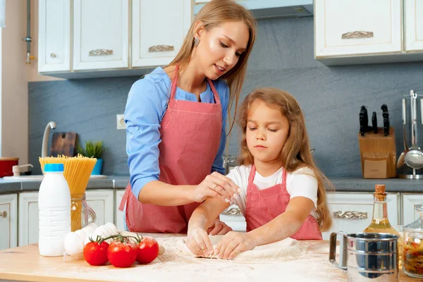 Mãe e sua filhinha preparando massa na cozinha — Fotografia de Stock