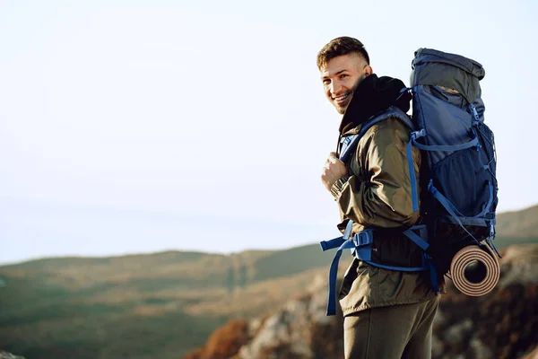 Молодий білий чоловік мандрівник з великим рюкзаком, що ходить по горах — стокове фото