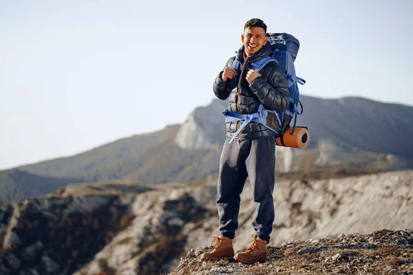 Male backpacker in hiking equipment standing at the top of the mountain — Stock Photo, Image