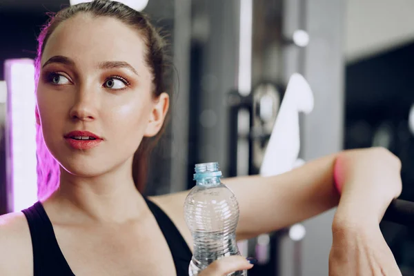 若いスポーティな女性がジムで水を飲む — ストック写真