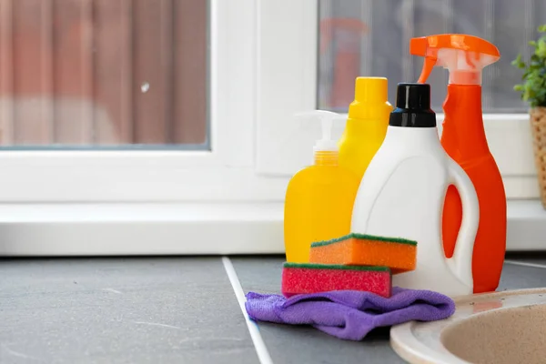 Cleaning detergents and tools on a kitchen counter