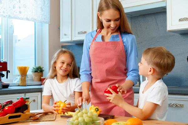 Moeder koken met haar kinderen in de keuken — Stockfoto