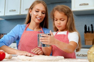 Anne ve küçük kızı mutfakta hamur hazırlıyorlar.