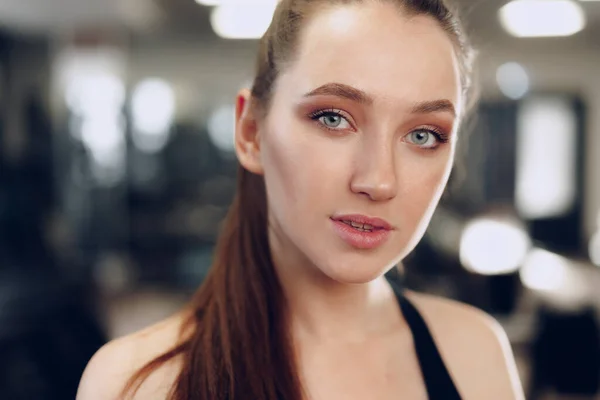 Portret van een jonge sportieve blanke vrouw training in een fitnessclub — Stockfoto