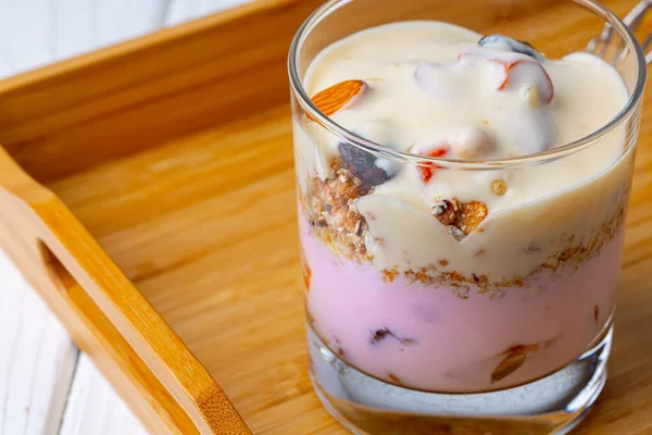 Sabroso desayuno con granola, yogur y frutas en un tazón de cristal —  Fotos de Stock