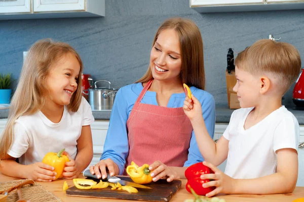 Moeder koken met haar kinderen in de keuken — Stockfoto