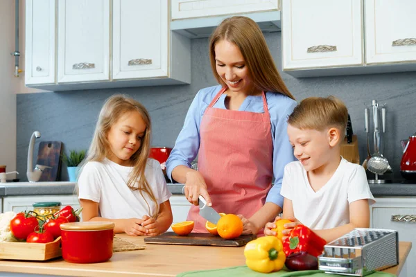 台所で子供たちと一緒に母料理 — ストック写真