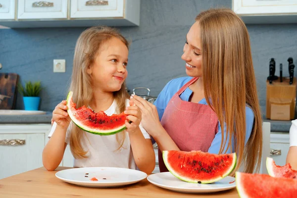 母親と娘食べるスイカに家 — ストック写真