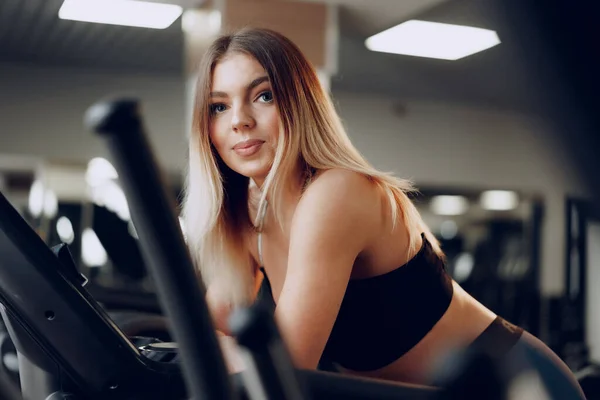 Adatto curvy giovane donna bionda formazione in una zona cardio in una palestra — Foto Stock